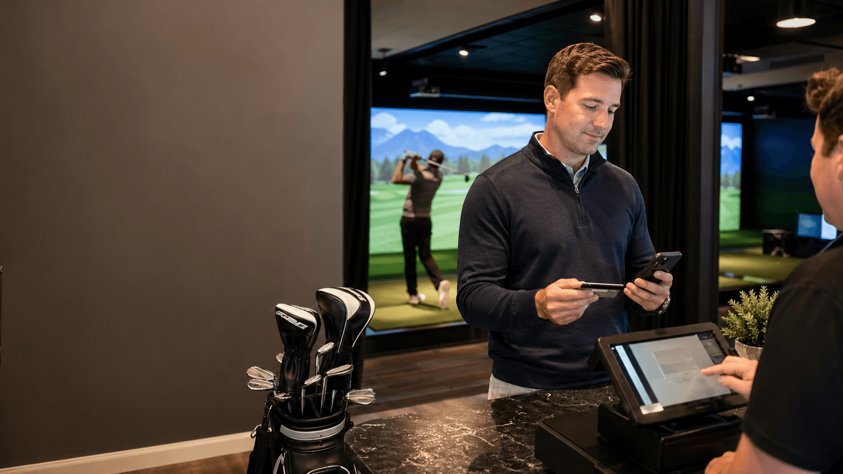 Customer paying for indoor golf simulator time at a venue check-in counter